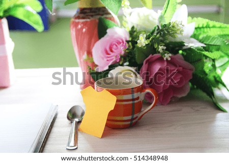  cup coffee and bouquet of flower on wood table