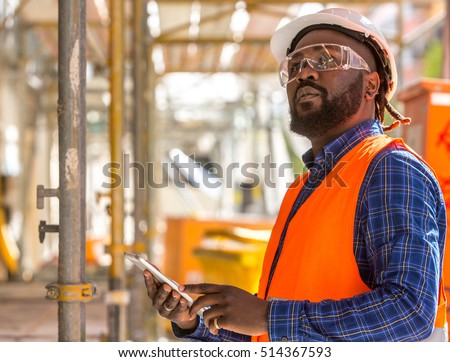 Attractive African american engineer at work on construction site Royalty-Free Stock Photo #514367593