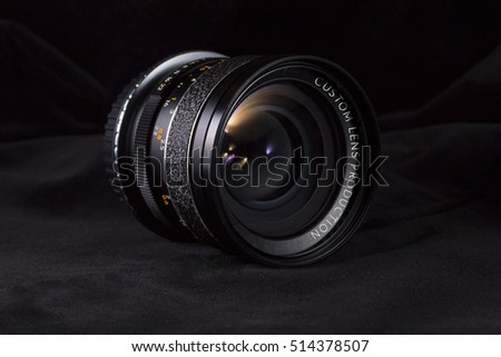 Black digital camera lens with custom optics production concept.Custom optics production on Digital Camera Lens. Lens with colorful flares on dark background.