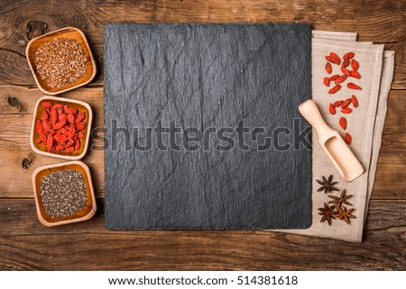 Flax and chia seeds and goji in a wooden bowls on wooden background, healthy superfood, top view