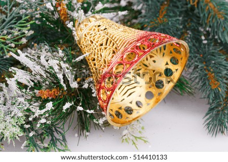Christmas bell and fir-tree branch on gray background.
