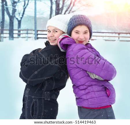 teen girls in winter clothes outdoor o ice rink close up photo on snow background