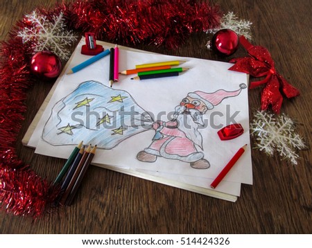 Child's drawing of Santa Claus with a bag of gifts. Celebratory tinsel and pencils around the picture