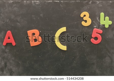 colorful plastic alphabet on chalkboard background