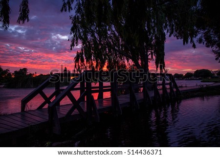 Pink, red and orange African sunset over park with park bridge in Cape Town South Africa