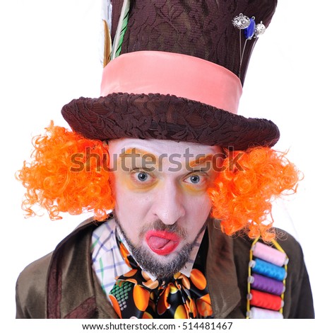 The insane funny Hatter: a man with red hair dressed in a velour brown frock coat and the bow tie grimacing showing tongue - square close-up portrait, isolated