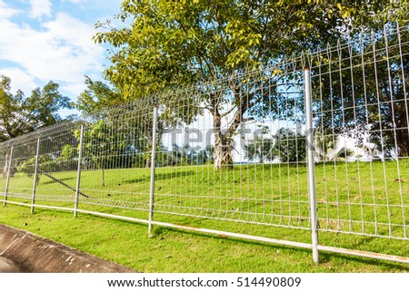 Metal fence wire in plublic garden Royalty-Free Stock Photo #514490809