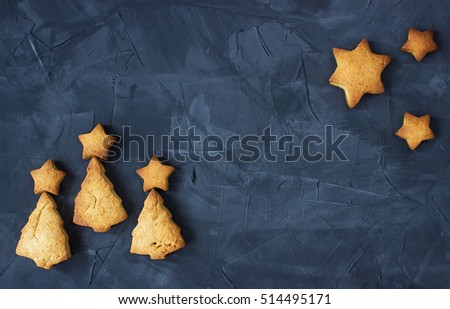 background with baked star-shaped and christmas tree - shaped gingerbread on the concrete background. creative idea
