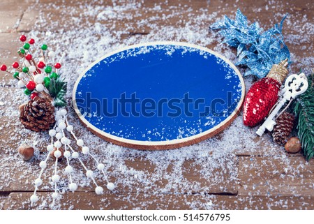 Blank Blue Chalkboard With Chritmas Decoration For Making Signs On Snowy Wooden Background. Selective Focus. Copy Space.