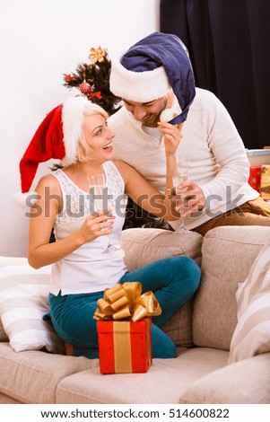 Picture of beautiful happy Christmas couple celebrating New Year at home atmosphere. Cheerful man and woman spending free time all together. New Year or Christmas concept.