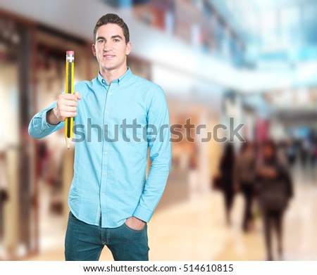 Happy young man holding a pencil
