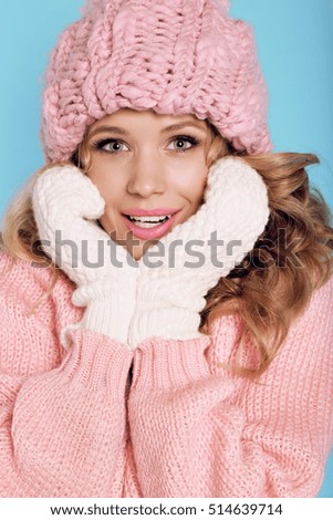 fashion studio photo of gorgeous young woman with blond curly hair in cozy warm clothes