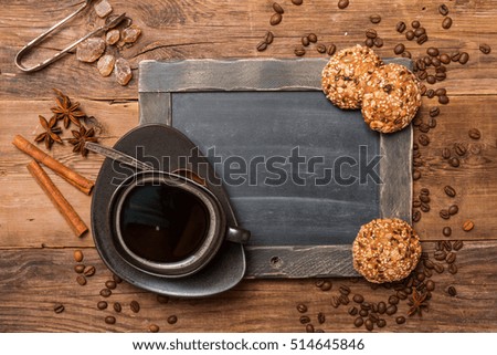 Cup of coffee and chalk board menu on wooden vintage background, top view
