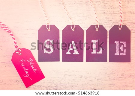 Tags with sale sign on wood board.