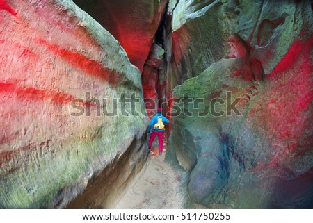 Ukrainian athlete tourist in Bubnyshche between rocks rock covers fire - an ancient pagan temple. Huge cliffs hovering over the scary footpath the famous place of attraction of the Carpathians