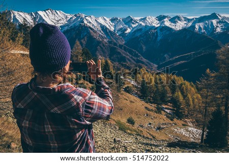 Girl taking picture of the mountains