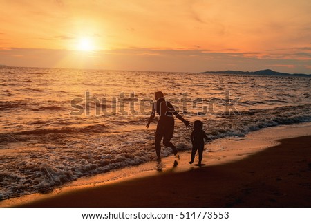 Mom ran to catch baby on the beach.