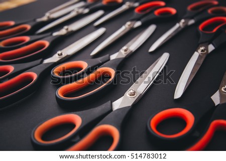 Red scissors are on the black table