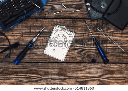 HDD with Professional Precision Screwdriver and Some Tools on Wooden Table