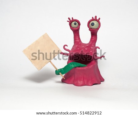 Cobbled together from plasticine funny original monsters. Holds a poster. Isolated character on white background Royalty-Free Stock Photo #514822912