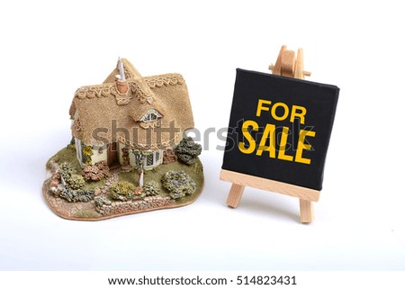 Miniature house with For Sale Sign White background