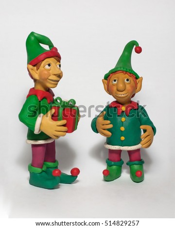 
Two little Christmas elf with a gift. Plasticine characters on a white background Royalty-Free Stock Photo #514829257