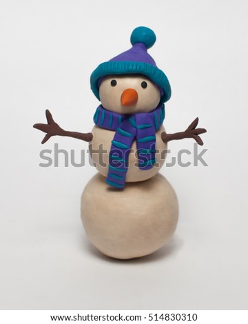 
Funny plasticine snowman in a blue hat and scarf isolated on white background Royalty-Free Stock Photo #514830310