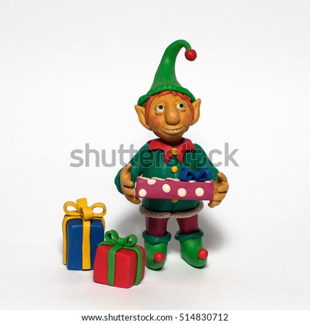 
Plasticine character. Funny Christmas elf holding a gift. Isolated on white background