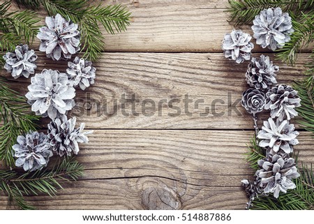 Fir branches with cones on old wooden boards. Christmas background. Space for text. Top view.