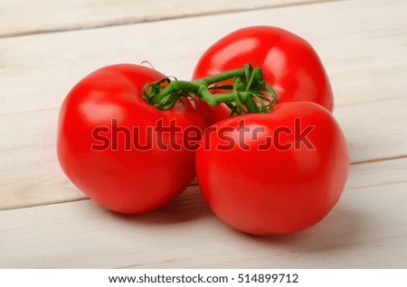 Bunch of the fresh tomatoes from the market on a wooden table