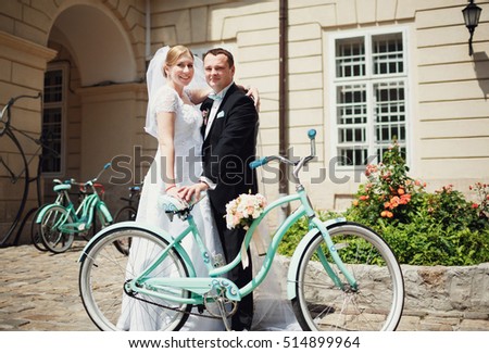 The charming brides stand near bicycle