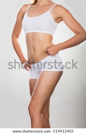 Woman's Stomach Pinching Excessive Fat On Grey Background