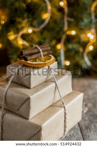 stack of packed gifts on the background of Christmas lights.