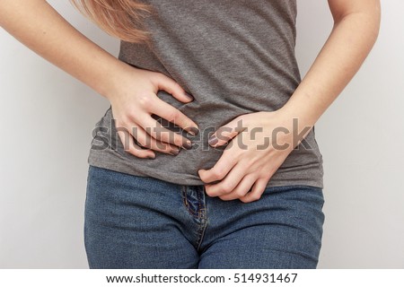 Young casual woman is having stomach ache. Woman making heart shape on her stomach. Gynecology, period, female healthcare, digestive system, Urinary Tract Infections Royalty-Free Stock Photo #514931467