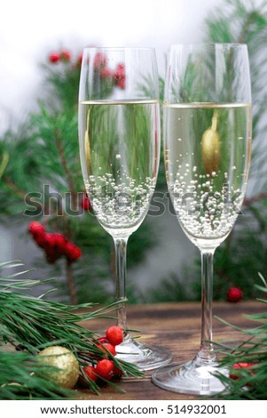 Christmas and New Year seasonal composition with pine tree branches, two glasses of champaign, golden balls ornament and red rowan berries
