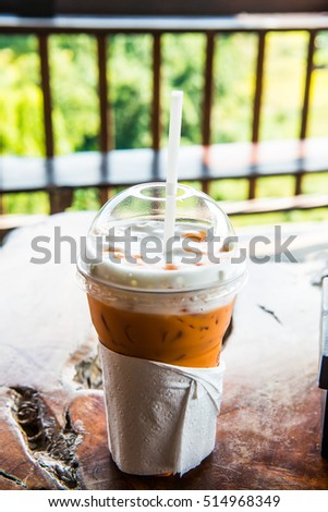 Iced Milk Tea in Plastic Glass with Natural View, Thailand.