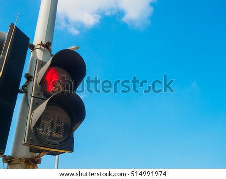Traffic light shows red light for pedestrians with blue sky