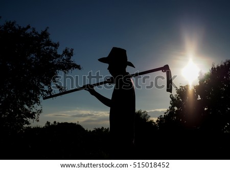 Silhouette of a farmer with sunset in nature landscape