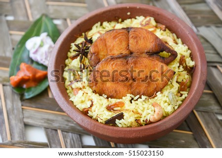 Top view Fish Biryani/fried rice, Kerala/Goa India. Popular Indian dish/seafood made of king/barracuda/seer fish marinated in Indian spices/masala fresh herbs, cooked with basmati/saffron in clay pot.