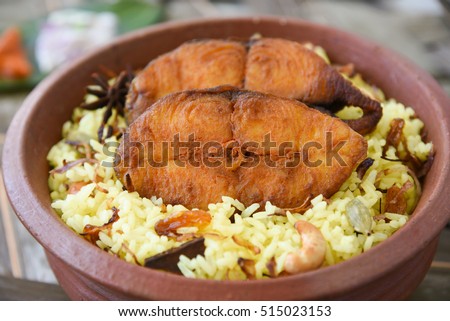Top view Fish Biryani/fried rice, Kerala/Goa India. Popular Indian dish/seafood made of king/barracuda/seer fish marinated in Indian spices/masala fresh herbs, cooked with basmati/saffron in clay pot.