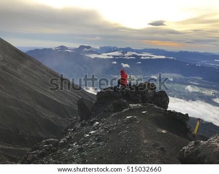 Hiker stand in mountain Kerinci with beautiful Danau Tujuh lake in background during sunrise moment.  Royalty-Free Stock Photo #515032660