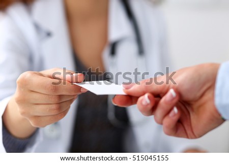 Female physician hand give white blank calling card to businesswoman closeup in office. Physical, disease prevention, examine patient, instrument shop, healthy lifestyle, family doctor concept Royalty-Free Stock Photo #515045155