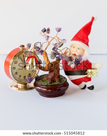 Twelve five minutes and Santa Claus with gifts in hand is standing beside a Christmas tree with leaves of amethyst