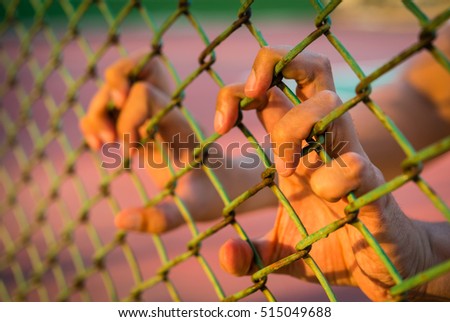 hand holding on chain link fence