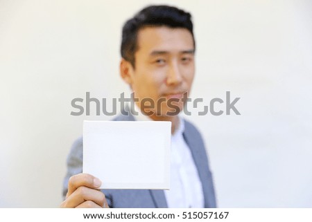 smile Asian business man hold white card paper with white background