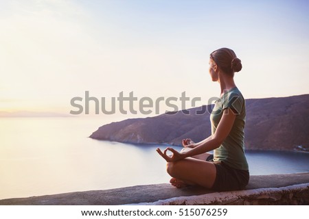 Young woman practicing yoga outdoors. Harmony and meditation concept. Healthy lifestyle