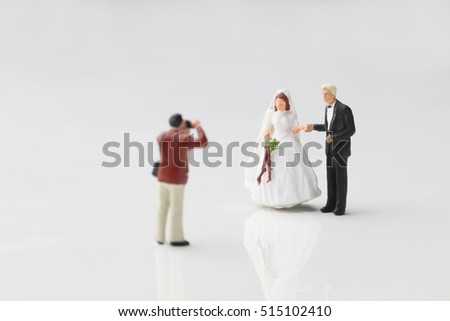Wedding photographer taking photographs of couple.