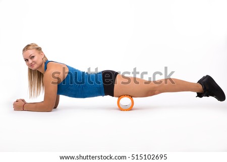Picture of happy fitness woman doing push ups while training with massage device isolated on white background in studio.