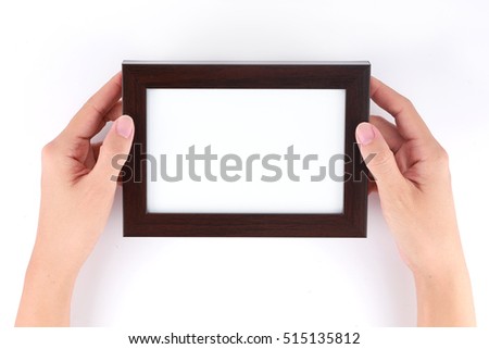 Female hand holding blank wooden picture frame on white background 