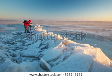 Photographer take pictures on the river bank in winter